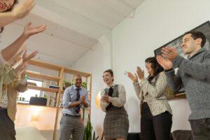 Coworkers in the office clapping at someone's success